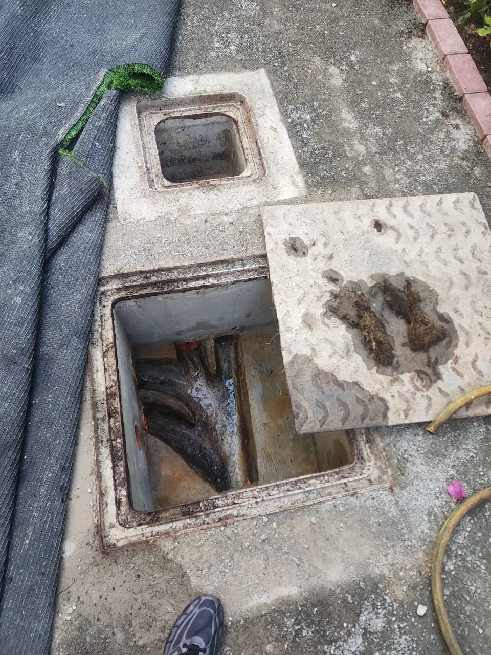 Outdoor inspection chamber opened for drainage cleaning and blockage removal