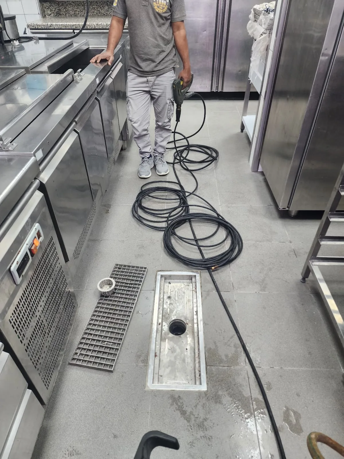 Commercial kitchen drain cleaning work with cable equipment and floor drain access