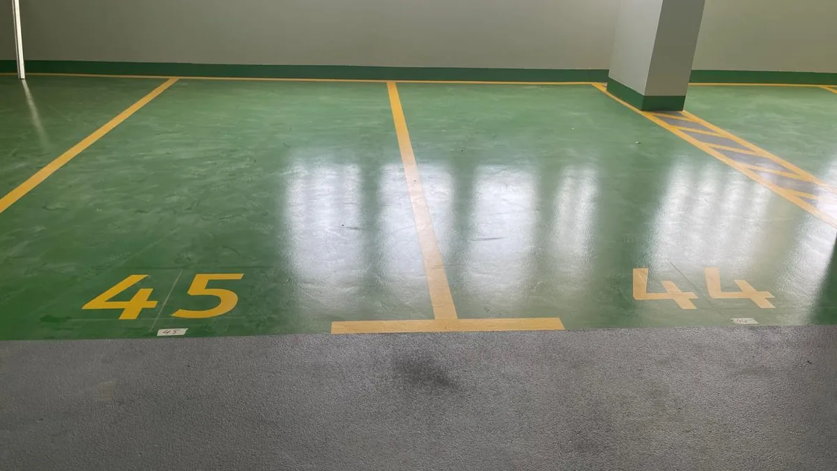 Green epoxy parking bay with yellow line marking in Dubai