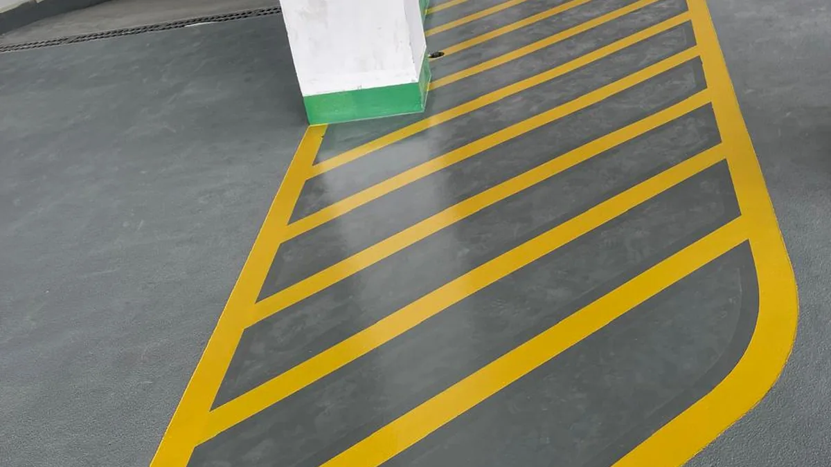 Yellow safety line marking on grey epoxy parking floor